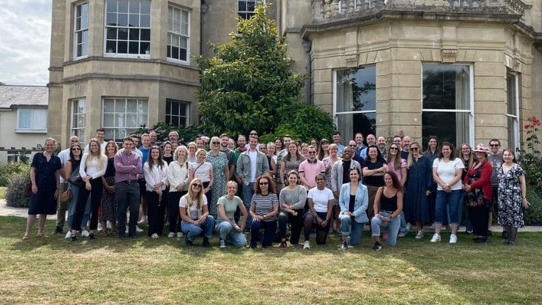 Paradigm Norton team photo outside a brick building